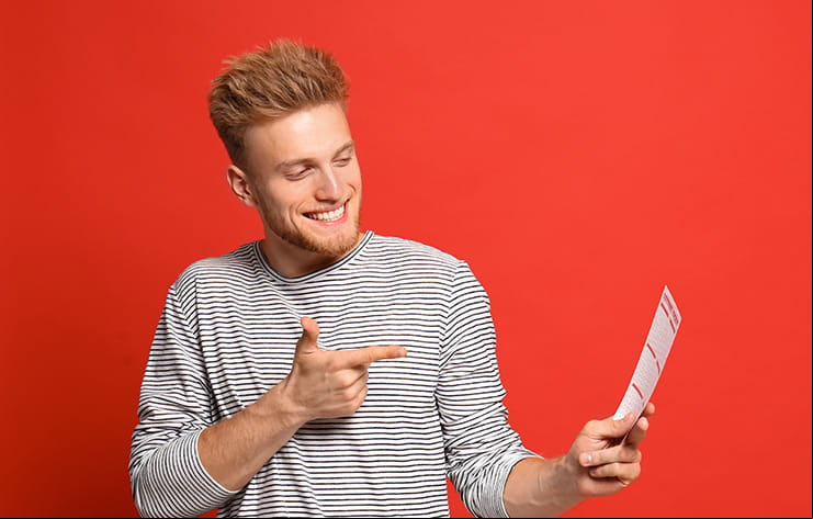 A man pointing at a lottery ticket.